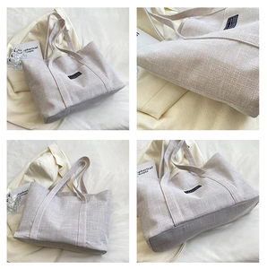 Detail view of canvas tote bag with woven texture and minimalist stitching details