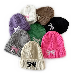 Detail showing various colors of children knit hats with cute bow embroidery