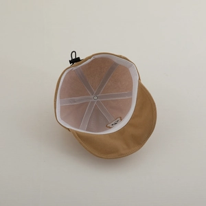Internal view of brown baby cap showing sweatband with bear embroidery and adjustable cord