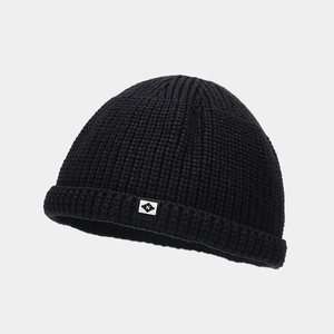 Détail du bonnet docker en tricot noir montrant la texture épaisse et le logo N brodé
