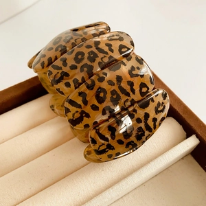 Détails de segments en résine à motif léopard et cordon élastique sur un bracelet large