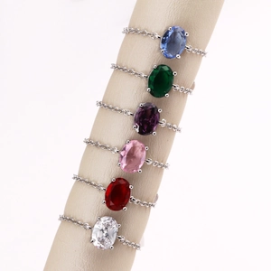 Macro detail of oval colorful zircon stones on gold-plated chain rings in various colors