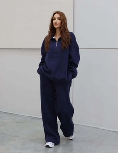 Détail d'un ensemble de sport bleu marine avec sweat demi-zip et pantalon large