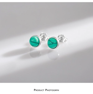 Detail view of S925 sterling silver turquoise stud earrings with hallmark on grey background