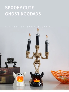 Close-up of Halloween LED ghost candle and skull candelabra decor on a styled tabletop