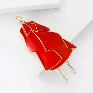 Detailed view of red enamel fashion lady brooch with gold metallic frame on white background