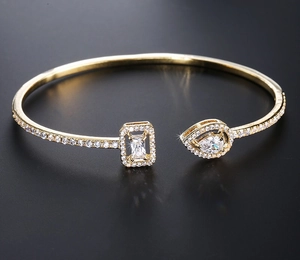 Detail of gold open bracelet featuring teardrop and rectangular cut zircon stones