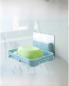 Detail of wall-mounted self-draining soap holder with a soap bar on tiled bathroom wall