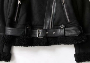 Détail de la veste aviateur noire avec ourlet en peau lainée et ceinture à boucle métal