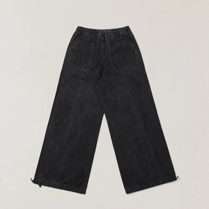Macro view of washed black cargo pants featuring elastic waist and drawstring hem detail