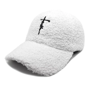 Détail de la casquette sherpa blanche avec broderie Faith noire et texture douce en laine bouclée