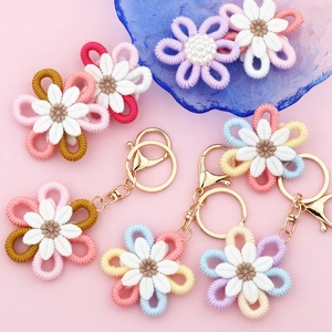 Handmade crochet daisy flower keychains with golden clasps in various pastel colors
