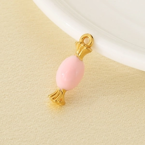 Detailed view of pink enamel candy pendant with gold pleated tips and jump ring