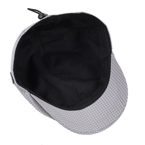 Detail of grey plaid beret showing 100% polyester wash label and internal lining