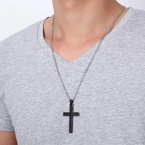 Silver chain necklace with a sleek black cross pendant on model, showing length and fit