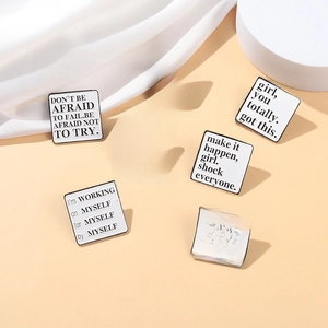 Enamel pins with motivational quotes like Don't Be Afraid To Fail in black and white