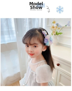 Girl's Frozen inspired mesh flower hair clip with unicorn detail shown on child model