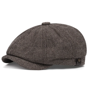 Detail of vintage herringbone newsboy cap with premium tweed texture and metal logo