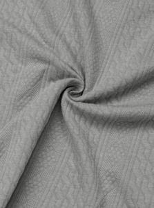 Close-up of gray knit fabric showing the intricate geometric diamond weaving pattern