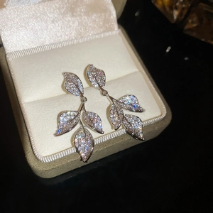 Macro view of silver leaf tassel drop earrings with sparkling cubic zirconia stones