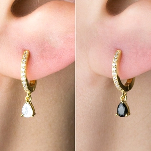 Detail of S925 silver huggie hoop earrings with pear-cut white and black gems
