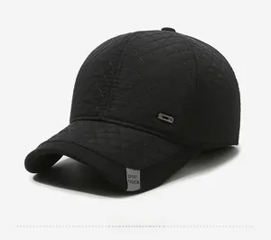 Detail view of black quilted baseball cap featuring sport fashion label and metal button