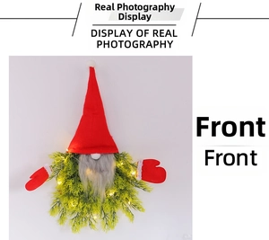 Close-up of lighted Christmas gnome wreath with red knit hat and warm LED lights