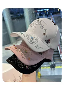 Macro detail of rhinestone flower and butterfly decorations on baseball caps in three colors