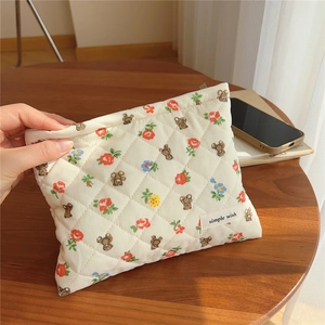 Detail of cream quilted cotton pouch with red floral and brown bear pattern