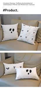 Detailed tufted ghost embroidery on white canvas Halloween pillow covers on a leather sofa