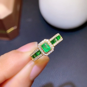 Luxurious emerald cut green stone ring in gold finish with micro-paved sparkling diamonds
