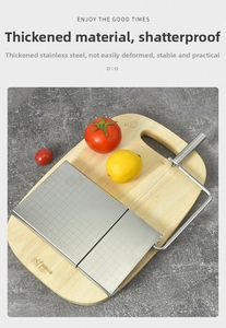 Close-up of stainless steel cheese slicer with 1-13cm scale on wooden cutting board