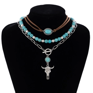 Detail of bohemian layered necklace with turquoise beads and silver longhorn skull pendant