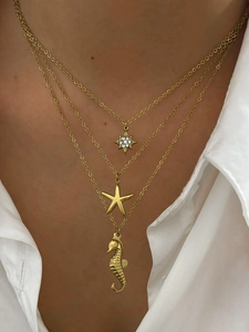 Collier doré à trois rangs avec pendentifs hippocampe et étoile de mer sur modèle