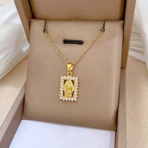 Detail of gold pendant featuring Virgin Mary relief with sparkling zircon frame in a box