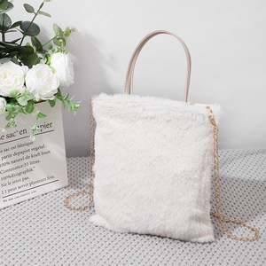 Borsa a mano bianca in ecopelliccia con catena in metallo e manico in pelle in posa soft