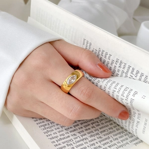 Macro detail of 18K gold-plated titanium ring with marquise-cut zircon on wide band