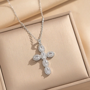 Silver stainless steel cross necklace with inlaid zircons on a satin background display