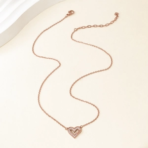 Detail of rose gold heart pendant necklace with shimmering white zircon inlay for women