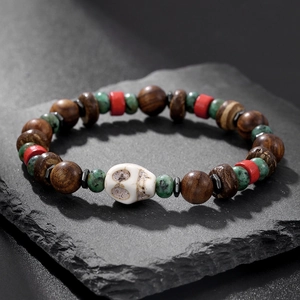Vue macro de bracelet en perles de santal et coco avec breloque crâne sur pierre