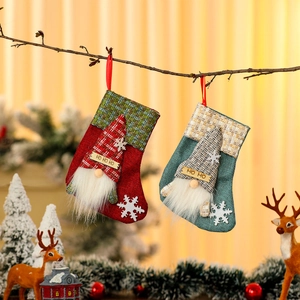 Christmas burlap stockings with gnome figurines and HO HO HO signs on wooden branch