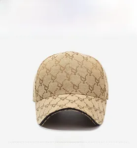 Close-up of khaki baseball cap with brown monogram jacquard and black piped brim detail