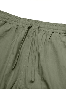 Detail of olive green trousers with elastic waistband and adjustable drawstring