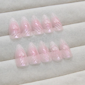 Faux ongles roses avec motifs de cœur 3D et finition nacrée sur plateau à bijoux
