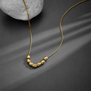 Elegant gold titanium steel necklace with seven olive beads on a delicate box chain