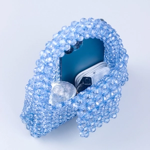 Macro shot of blue acrylic beaded bag showing internal capacity for phone and perfume