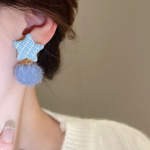 Nahaufnahme von Stern-Tweed und Kunstpelz-Bommel-Ohrringen in Hellblau am Model