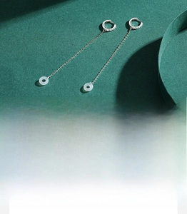 Macro detail of S925 sterling silver stamp on tassel earrings with cubic zirconia and ring