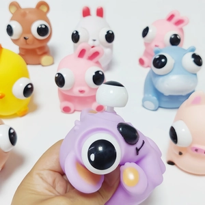 Close-up of squeezing action showing the pop-eye feature on a soft cartoon animal toy