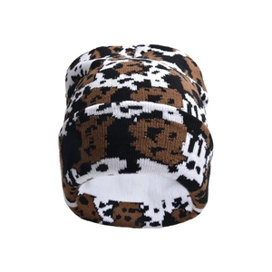 Close-up of thick camouflage knit texture on warm winter beanie with brown and white patterns